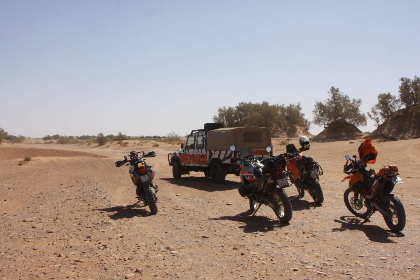 Motorräder und das Support-Fahrzeug Landrover Defender in den Sanddünen vor der Oasenstadt Mhamid nahe Zagora