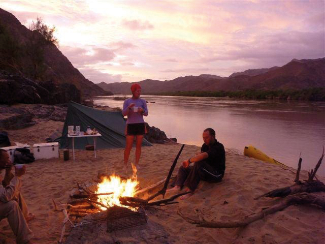 Camping am Gariep River (Orange River) in Namaqualand, Lagerfeuer am Flussufer bei Sonnenuntergang